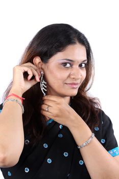 A portrait young Indian woman wearing silver earrings.