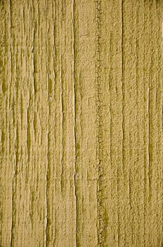 Yellow flaky paint on a wood background.