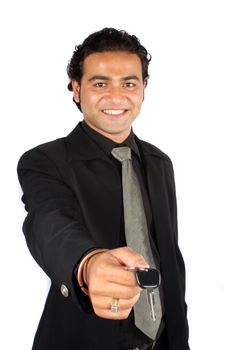A young Indian businessman handing over the keys of a new car to a customer, isolated on white studio background.