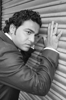 A black & white portrait of a handsome Indian guy in a suit.
