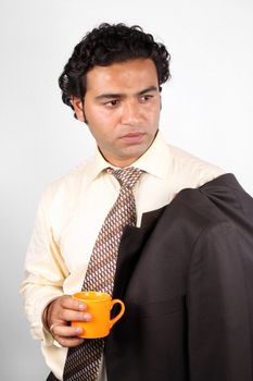 A stylish Indian businessman holding an orange coffee mug.