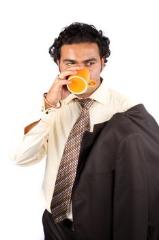 A handsome Indian businessman drinking coffee during a break, on white studio background.