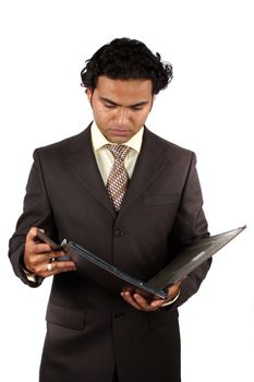 A young Indian businessman checking documents in a file, on white studio background.