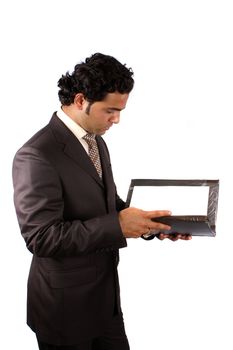 A young Indian businessman reading documents from a file, on white studio background.
