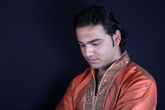 A portrait of a worried Indian man, in a traditional attire.