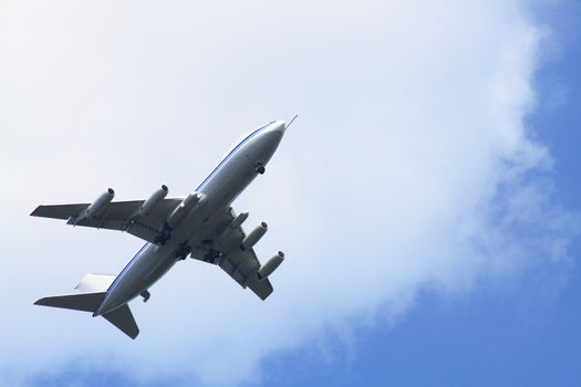 Big passenger airplane on background with blue sky and clouds