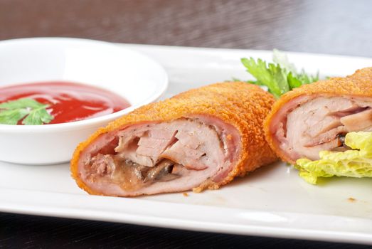 Closeup of rolls from pork meat, champignon mushroom, cheese and sauce