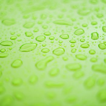 Green plastic surface with drops of water - backdrop