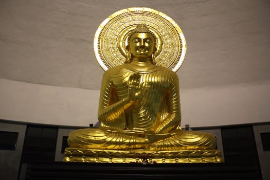 A huge golden statue of the Buddha in India.