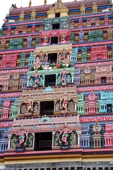 Colorful artistic sculptures of gods and goddesses on an ancient Hindu temple, in India.