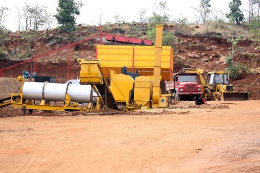 Machinery setup,bulldozer,crane and a transportation truck at a stone quarry in India.