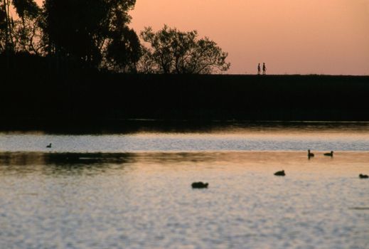 Walk by lake at sunset