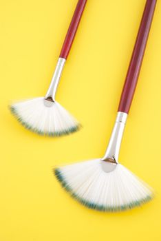 Art brushes on bright yellow background.
