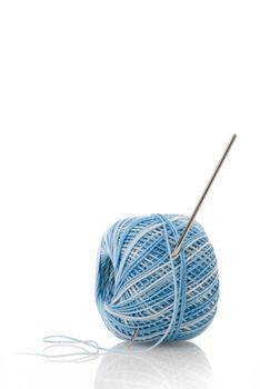 Blue spool and needle on a white background.