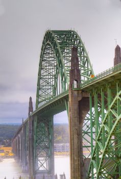 Old green metal bridge disappearing into the mist