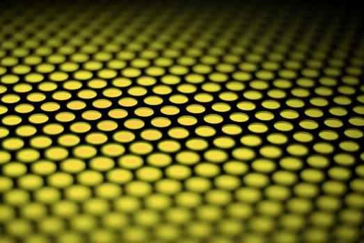 A metalic reflective surface back lit by a colorful light.