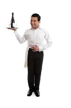 Smiling waiter, butler, bartender ot other attendant holding a silver tray with a bottle or wine and glasses.  White background.