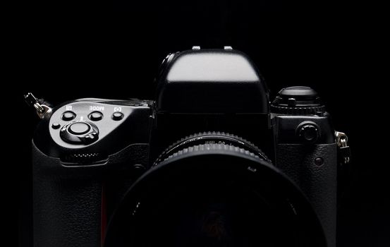 Professional digital camera over black background. 