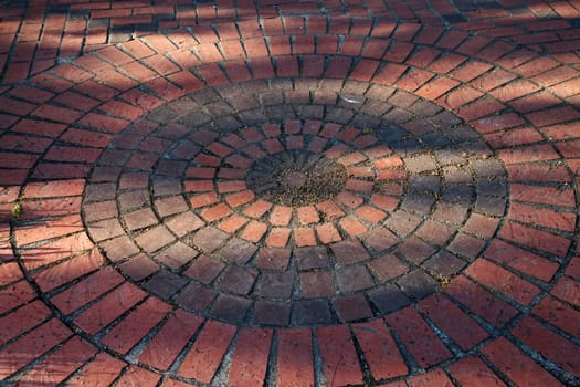 Circles of different colored and sized red bricks