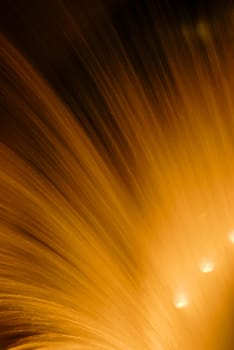 Articial waterfall at night back lit by orange light.