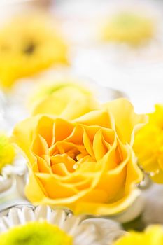 A decoration of a yellow rose on a bright background