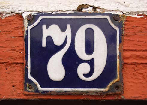 House number tile plaque with floral ornament. 
Over brickswood