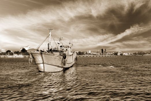 Landscape of ocean scenery with boat on water under dramatic sky.