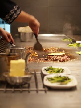 Chef cooking meat on a hot plate in a Japanese grill restaurant