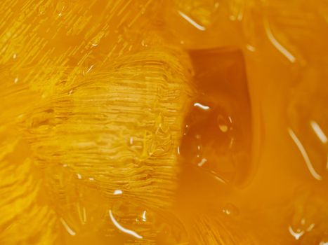 Closeup of a yellow syrup  with big blocks of ice
