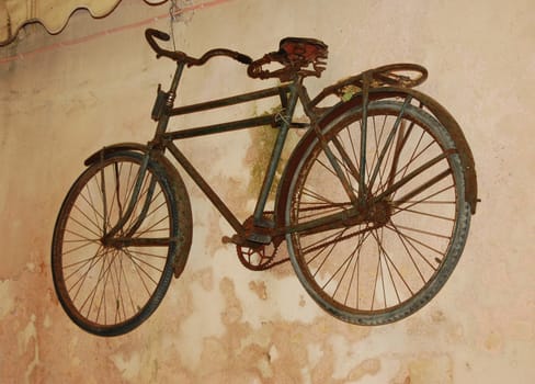 Very old bicycle on also old wall
