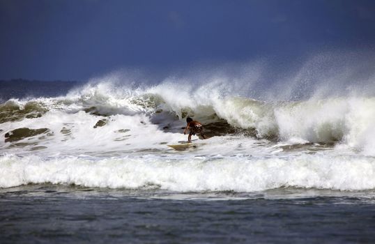 Young men - the surfer in ocean. Bali. Indonesia