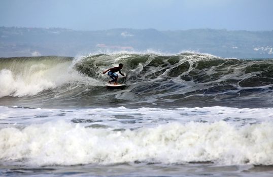 Young men - the surfer in ocean. Bali. Indonesia