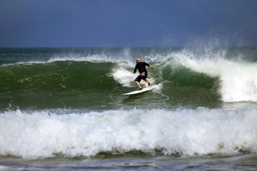 Adult men - the surfer in ocean. Bali. Indonesia