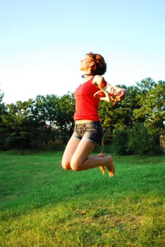 Happy woman jumping on grass