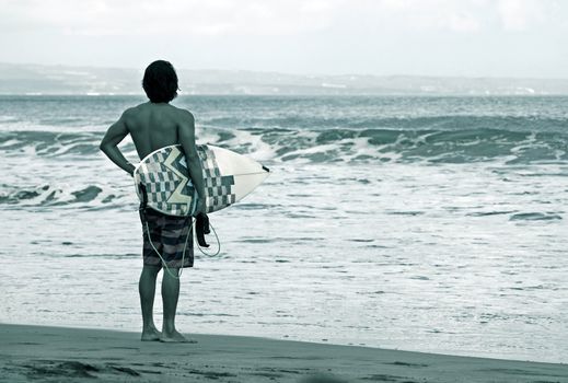 Lonely the man-surfer on a coastline. Bali