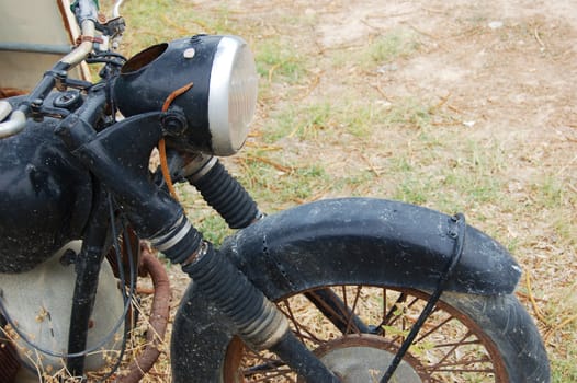 Old rusty damaged motorbike over grass.