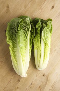 Romaine Lettuce on a wooden kitchen table, lit with a large light source from the right.