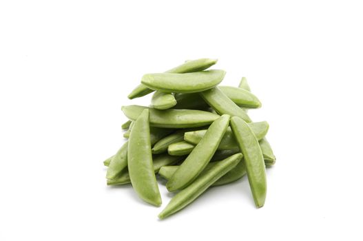 Sugar Snaps on a white table, lit with a large light source from the right.