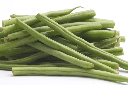 Fresh Long Green Beans, isolated on a white background table, lit with a large light source from the above right.