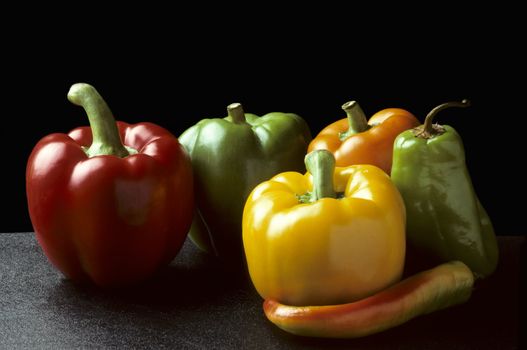 Bell and Chili peppers against black background Horizontal