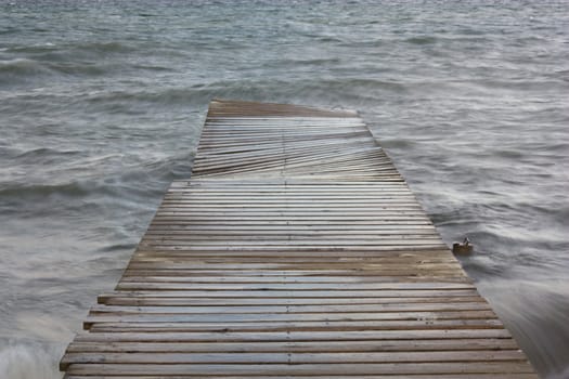 footbridge on the water in a cloudy day
