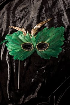 green mask for carnival on the black velvet