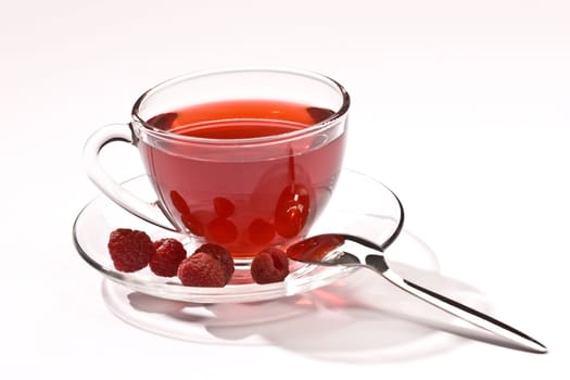 Cup of tea with raspberry syrup and some raspberries