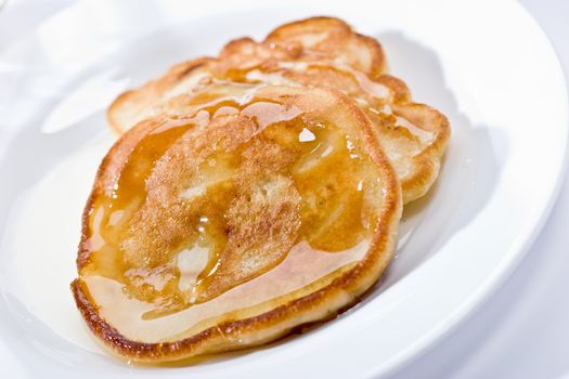 Two pancakes with honey on plate, lunch