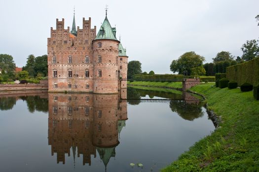 Egeskov castle slot landmark fairy tale castle in Funen Denmark view from the lake
