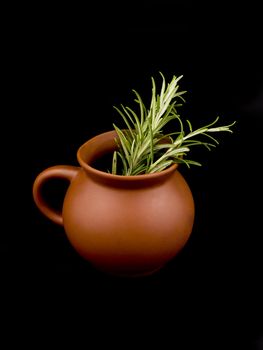 Ceramic cup and fresh rosemary on black background