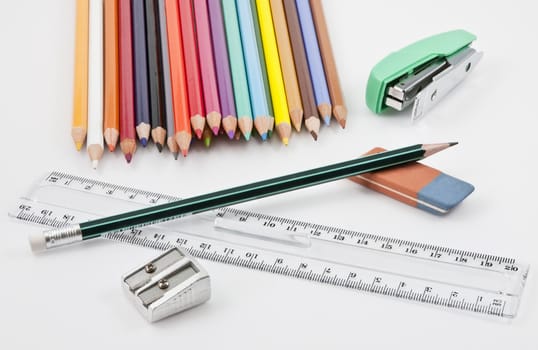 School supplies with colored pencils, pencil,  eraser, sharpener, stapler and plastic ruler