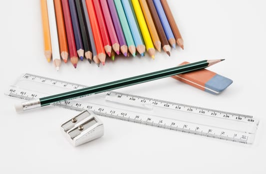 Basic school supplies with colored pencils, pencil,  eraser, sharpener and plastic ruler