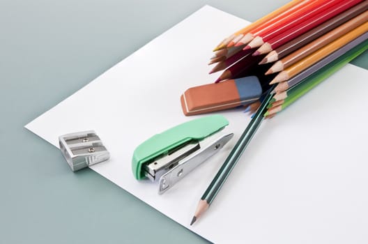 School supplies on a white paper outgoing of colored pencils tube