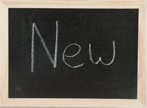 Black chalk board with wooden framed surround with the word New.